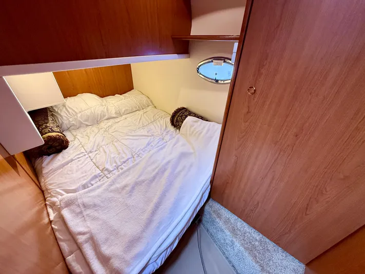  Yacht Photos Pics Cozy cabin interior of 2008 Silverton 33 Convertible yacht with bed and wooden paneling.