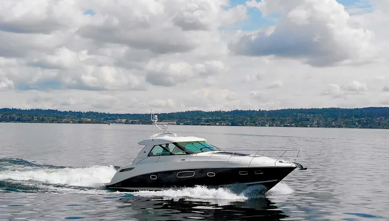  Yacht Photos Pics 2011 Sea Ray 450 Sundancer cruising on a calm lake under a cloudy sky.