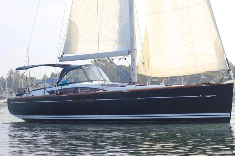 Tenacity Yacht Photos Pics 2011 Jeanneau 57 sailboat with white sails on calm water.
