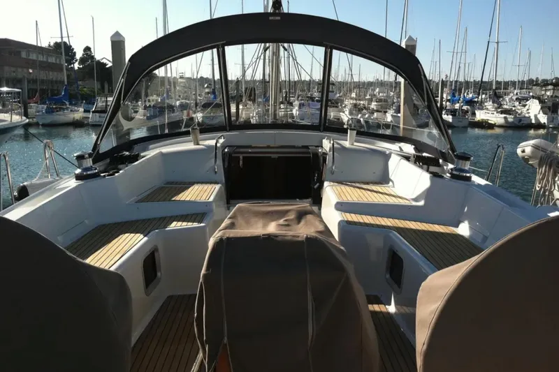 Tenacity Yacht Photos Pics 2011 Jeanneau 57 yacht cockpit with teak seating, docked in a marina.