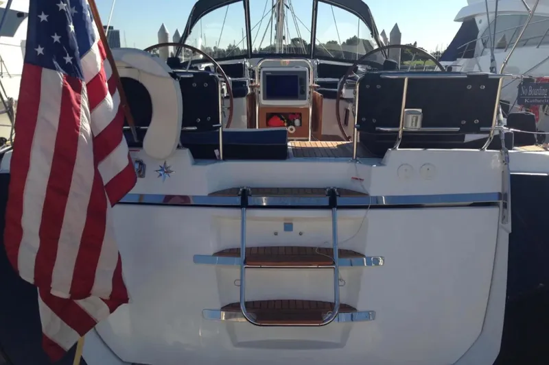 Tenacity Yacht Photos Pics 2011 Jeanneau 57 yacht with American flag, dual steering wheels, and sleek deck design.