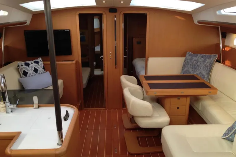 Tenacity Yacht Photos Pics Luxurious interior of a 2011 Jeanneau 57 yacht with elegant seating and wooden finishes.