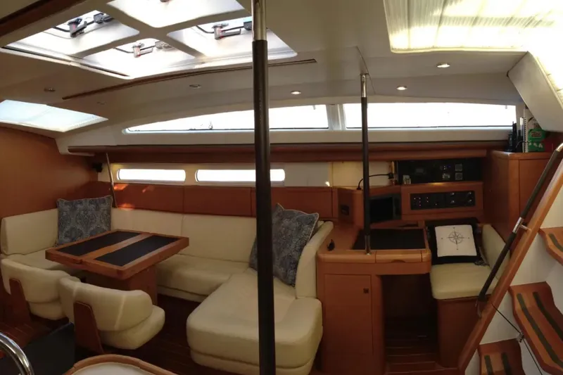 Tenacity Yacht Photos Pics Luxurious interior of a 2011 Jeanneau 57 yacht with elegant seating and navigation area.