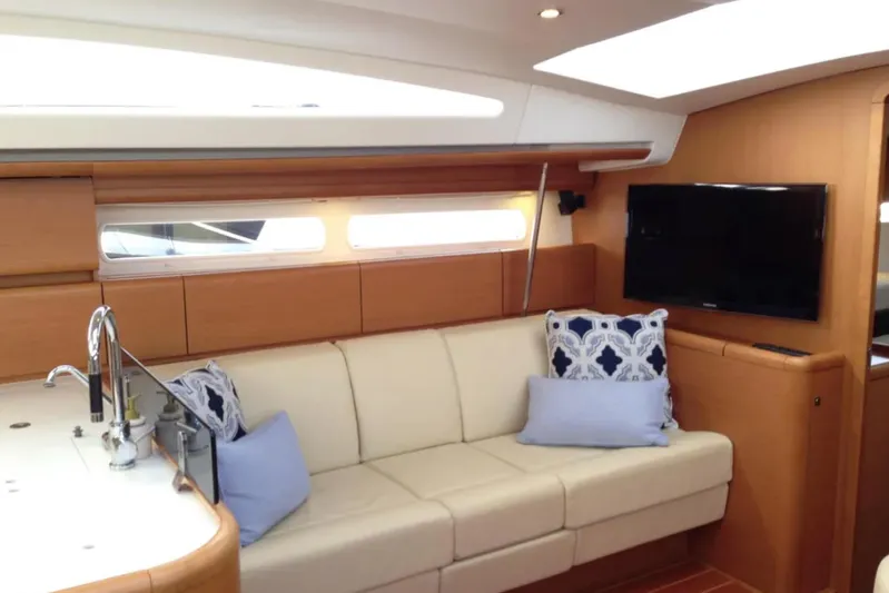 Tenacity Yacht Photos Pics Luxurious interior of 2011 Jeanneau 57 yacht with modern seating and TV.