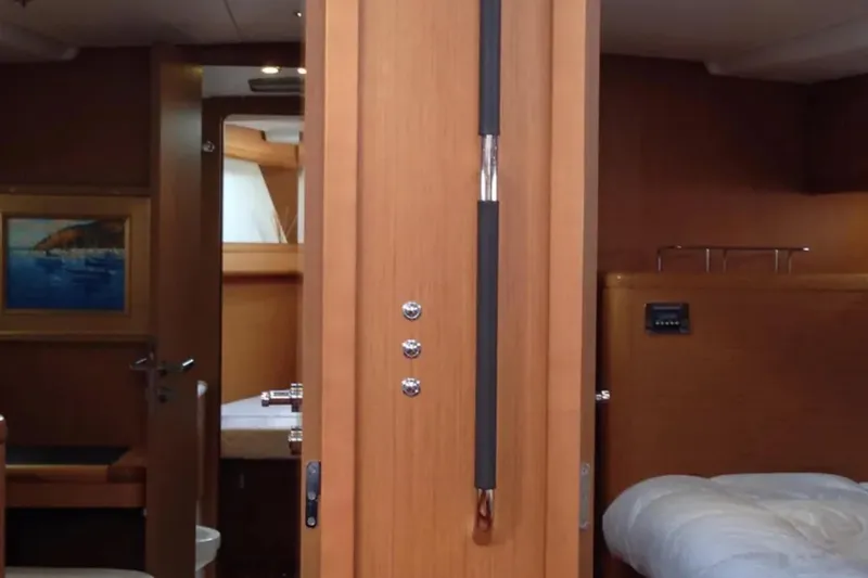 Tenacity Yacht Photos Pics Interior of 2011 Jeanneau 57 yacht, featuring wooden cabinetry and cozy sleeping quarters.