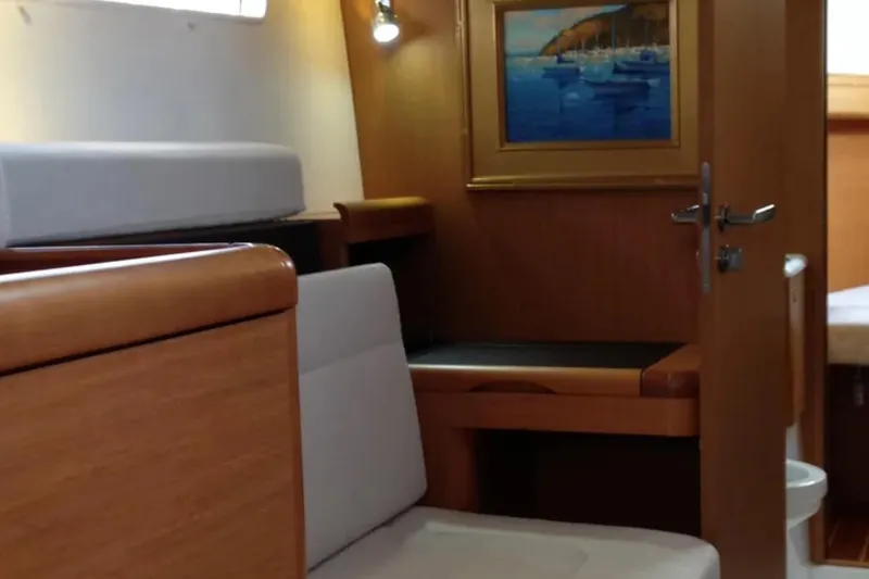 Tenacity Yacht Photos Pics Interior of 2011 Jeanneau 57 yacht with wooden furnishings and nautical artwork.