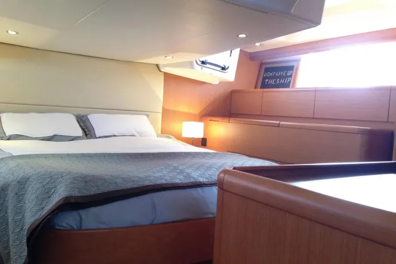 Tenacity Yacht Photos Pics Luxurious bedroom interior of 2011 Jeanneau 57 yacht with cozy bedding and ambient lighting.
