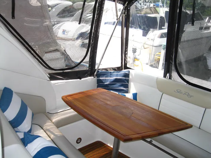  Yacht Photos Pics 2011 Sea Ray 350 Sundancer interior with wooden table and striped cushions.
