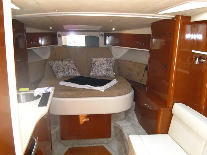  Yacht Photos Pics Interior of 2011 Sea Ray 350 Sundancer with cozy bed and wooden cabinetry.