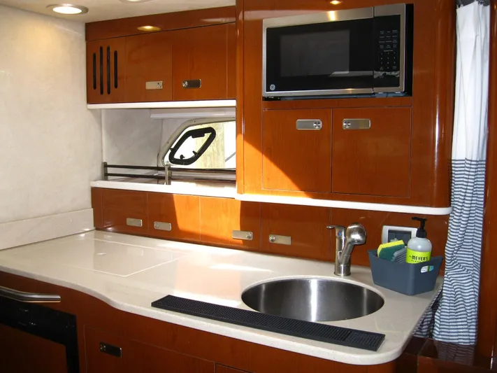  Yacht Photos Pics 2011 Sea Ray 350 Sundancer kitchen with sink, microwave, and wooden cabinetry.