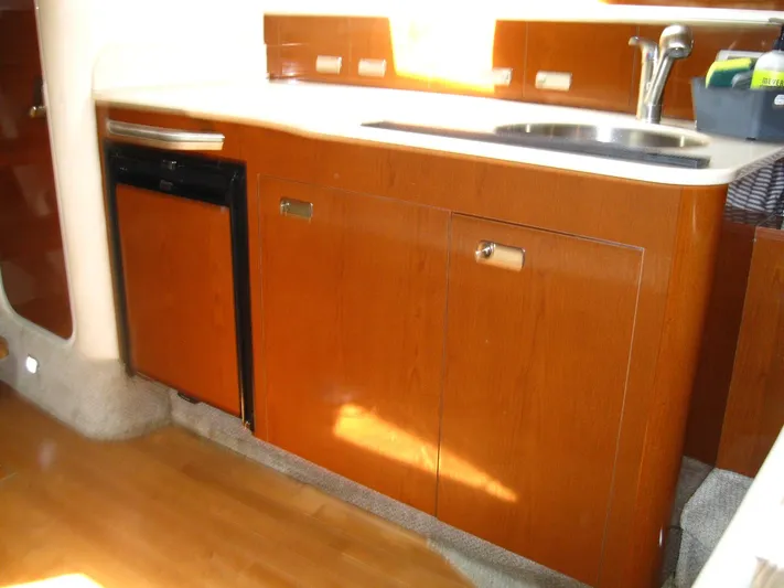  Yacht Photos Pics 2011 Sea Ray 350 Sundancer kitchen with wood cabinets, sink, and mini fridge.