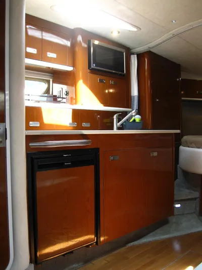  Yacht Photos Pics 2011 Sea Ray 350 Sundancer yacht interior kitchen with wood cabinetry and modern appliances.