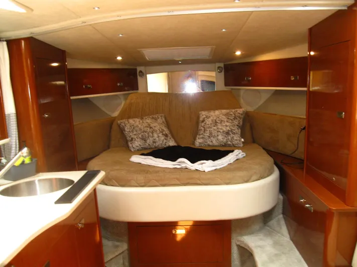 Yacht Photos Pics 2011 Sea Ray 350 Sundancer cabin interior with bed, pillows, and wooden cabinetry.