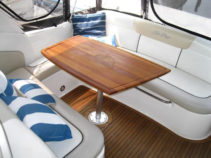  Yacht Photos Pics 2011 Sea Ray 350 Sundancer interior with wooden table, white seating, and striped cushions.
