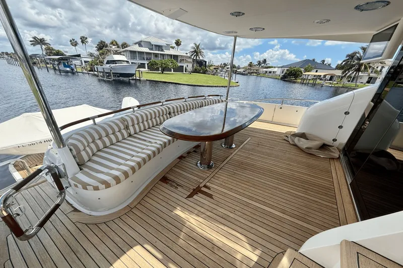 Marsha Sea Yacht Photos Pics Luxurious 2005 Lazzara 68 Flybridge yacht deck with striped seating and waterfront view.