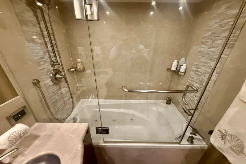 Marsha Sea Yacht Photos Pics Luxurious bathroom with glass shower and tub in 2005 Lazzara 68 Flybridge yacht.