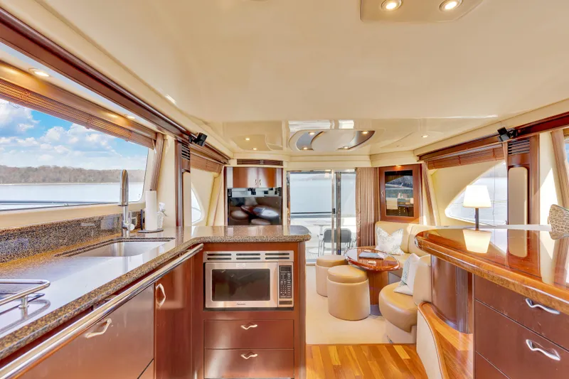  Yacht Photos Pics Luxurious interior of 2006 Sea Ray 58 Sedan Bridge yacht with modern kitchen and seating area.
