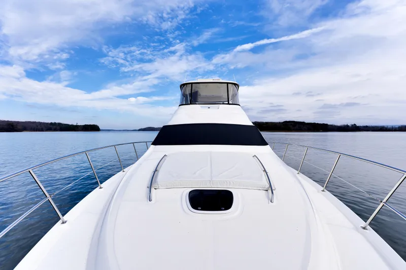  Yacht Photos Pics 2006 Sea Ray 58 Sedan Bridge yacht on calm water under blue sky.