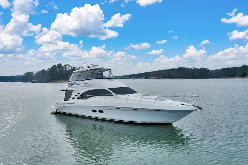  Yacht Photos Pics 2006 Sea Ray 58 Sedan Bridge yacht on calm water under a blue sky.