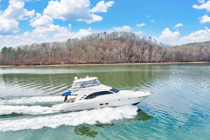  Yacht Photos Pics 2006 Sea Ray 58 Sedan Bridge cruising on a serene lake under a blue sky.