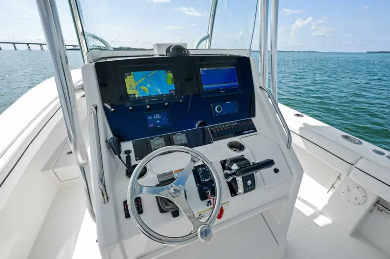  Yacht Photos Pics 2012 Regulator 32 FS boat helm with navigation screens and steering wheel on open water.