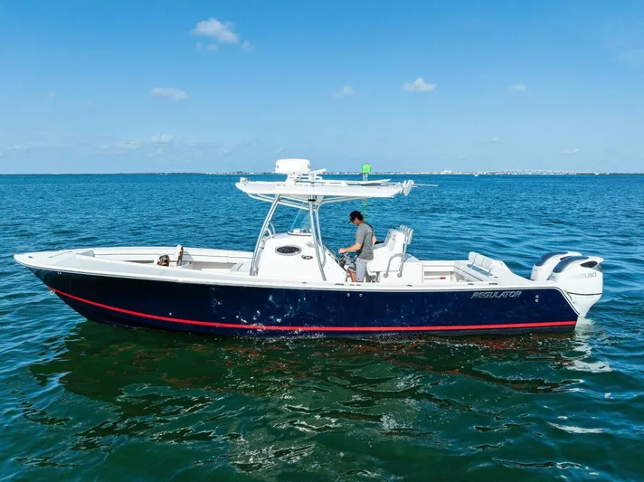  Yacht Photos Pics 2012 Regulator 32 FS boat on open water, clear sky, person onboard.