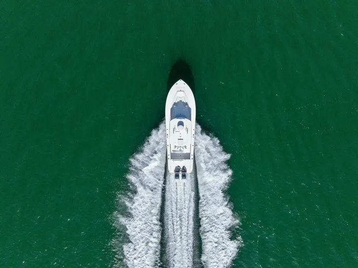  Yacht Photos Pics Aerial view of 2012 Regulator 32 FS boat cruising on green water.