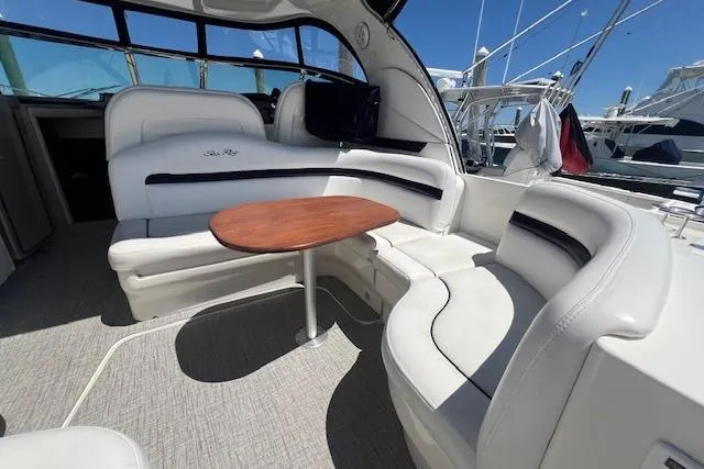 Irish Exit Yacht Photos Pics 2007 Sea Ray 38 Sundancer interior with white seating and wooden table, docked at marina.