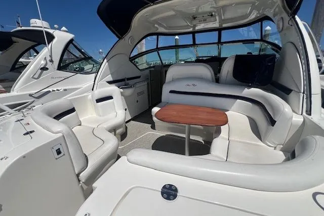 Irish Exit Yacht Photos Pics 2007 Sea Ray 38 Sundancer yacht interior with white seating and wooden table.