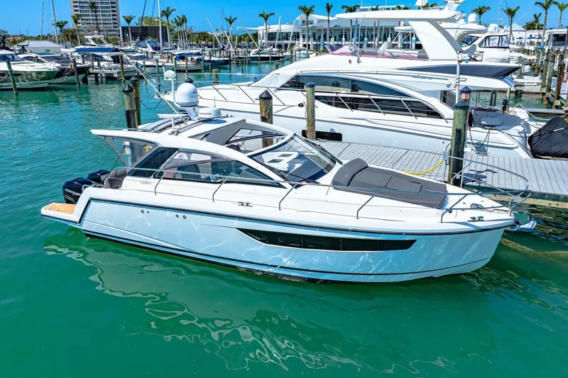  Yacht Photos Pics 2019 Sealine S330V yacht docked in a marina, surrounded by clear blue water.