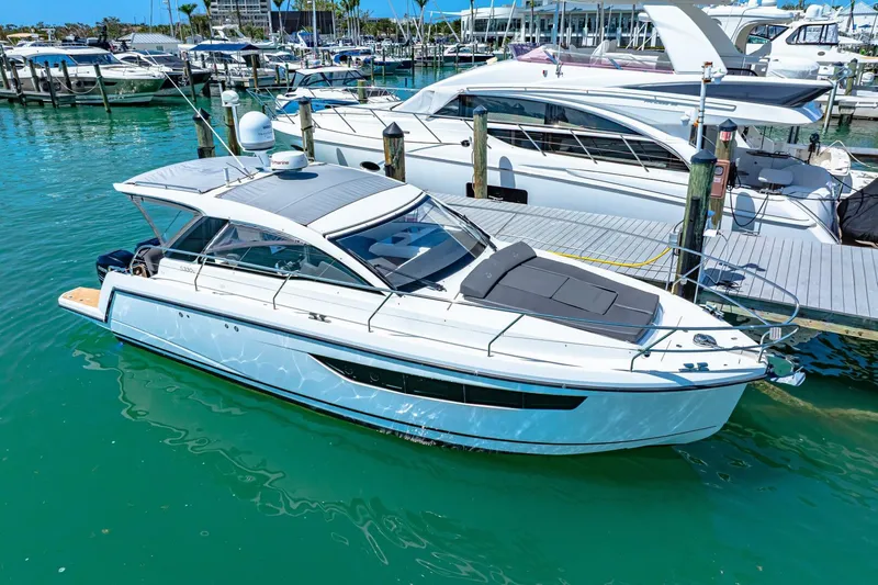  Yacht Photos Pics 2019 Sealine S330V yacht docked in a marina, surrounded by clear blue water.