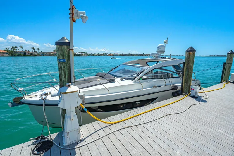  Yacht Photos Pics 2019 Sealine S330V yacht docked at a sunny marina with clear blue water.