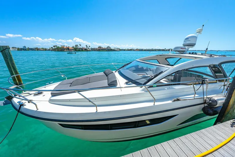  Yacht Photos Pics 2019 Sealine S330V yacht docked in clear turquoise water under a bright blue sky.