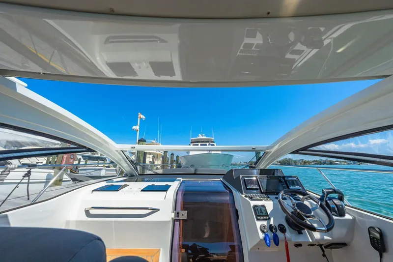  Yacht Photos Pics 2019 Sealine S330V yacht cockpit with modern controls, docked under clear blue skies.