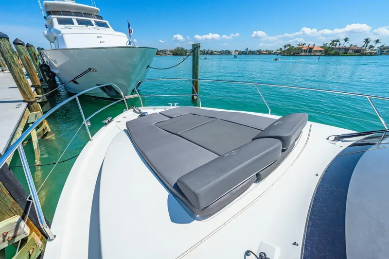 Yacht Photos Pics 2019 Sealine S330V yacht with sunbathing area, docked in clear blue waters.