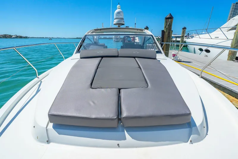  Yacht Photos Pics 2019 Sealine S330V yacht with sunbathing cushions, docked in a marina under clear blue skies.