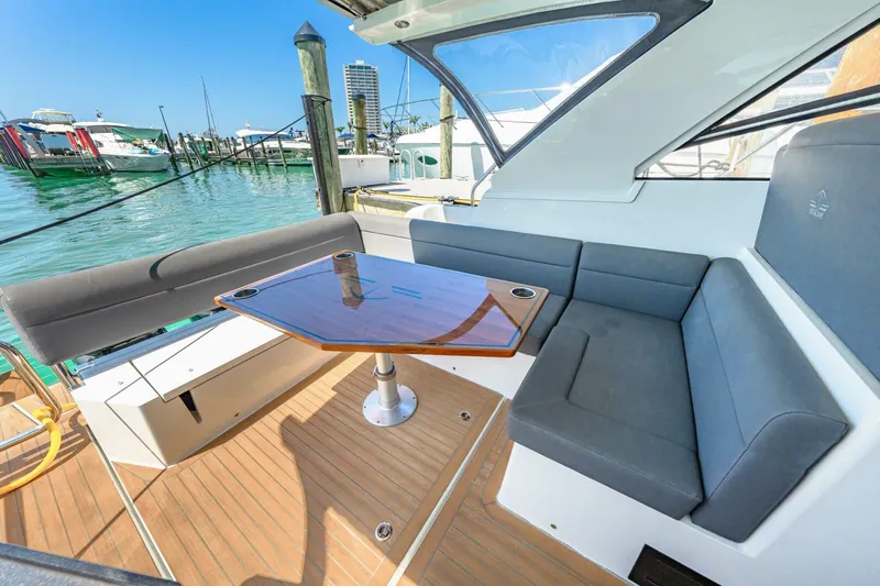  Yacht Photos Pics 2019 Sealine S330V yacht with sleek seating and table, docked at a marina.