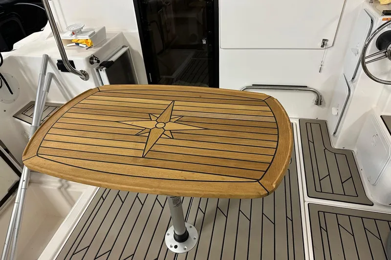  Yacht Photos Pics 2023 Cutwater C-32 Coupe interior with wooden table and nautical design.