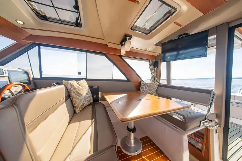  Yacht Photos Pics 2023 Cutwater C-32 Coupe interior with seating, table, and ocean view.