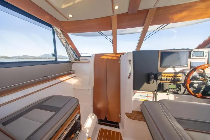  Yacht Photos Pics 2023 Cutwater C-32 Coupe interior with modern helm and panoramic windows.