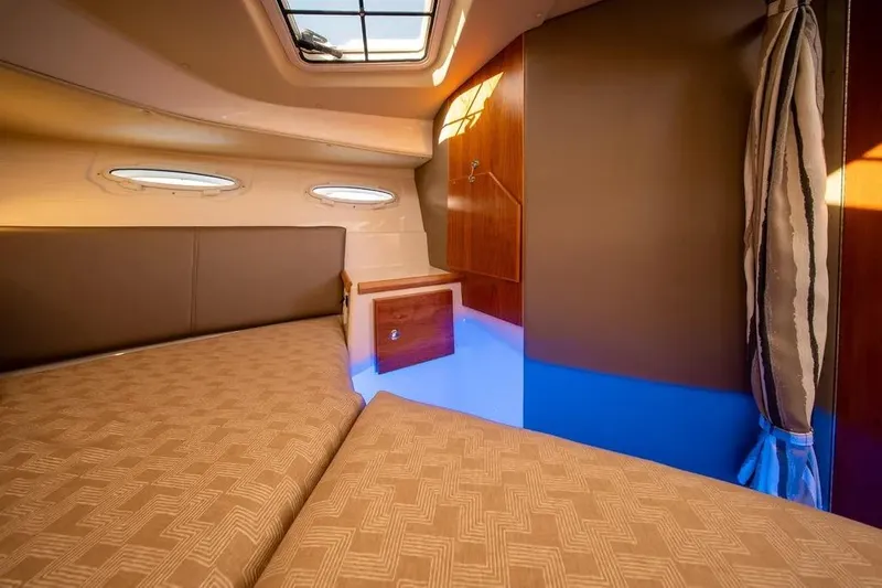  Yacht Photos Pics 2023 Cutwater C-32 Coupe cabin interior with cozy bedding and natural light.