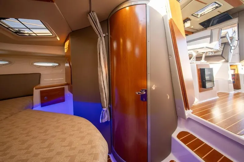  Yacht Photos Pics 2023 Cutwater C-32 Coupe interior with modern design, wood accents, and cozy sleeping area.