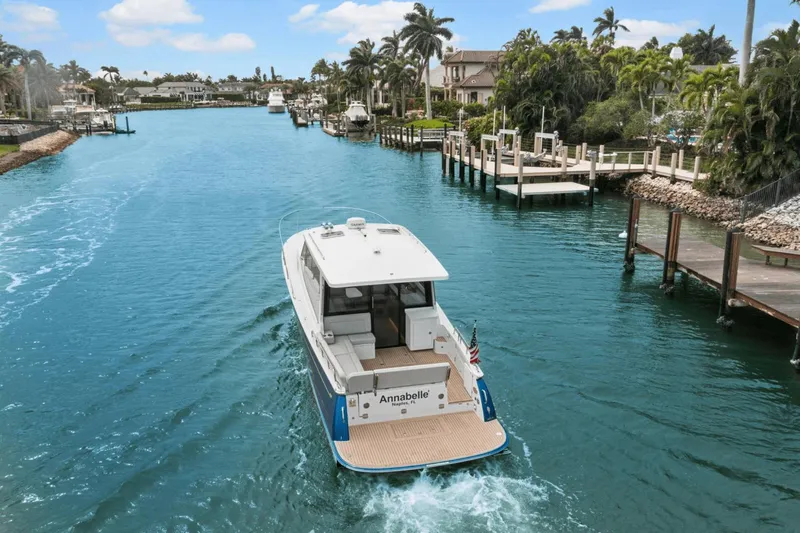 Annabelle IV Yacht Photos Pics 2024 MJM 42 boat cruising through a scenic, palm-lined waterway.