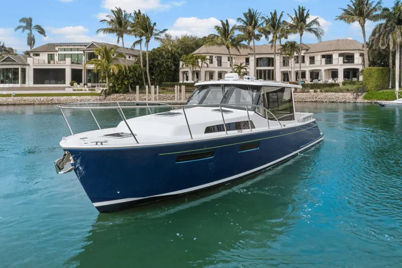 Annabelle IV Yacht Photos Pics 2024 MJM 42 yacht cruising in a luxurious waterfront setting with palm trees.