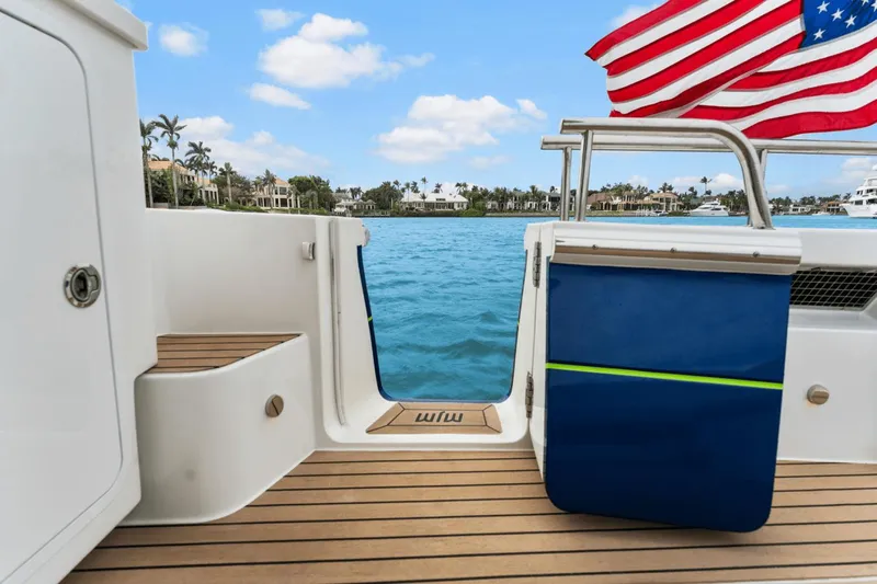 Annabelle IV Yacht Photos Pics 2024 MJM 42 yacht deck with American flag, overlooking serene waterfront homes.