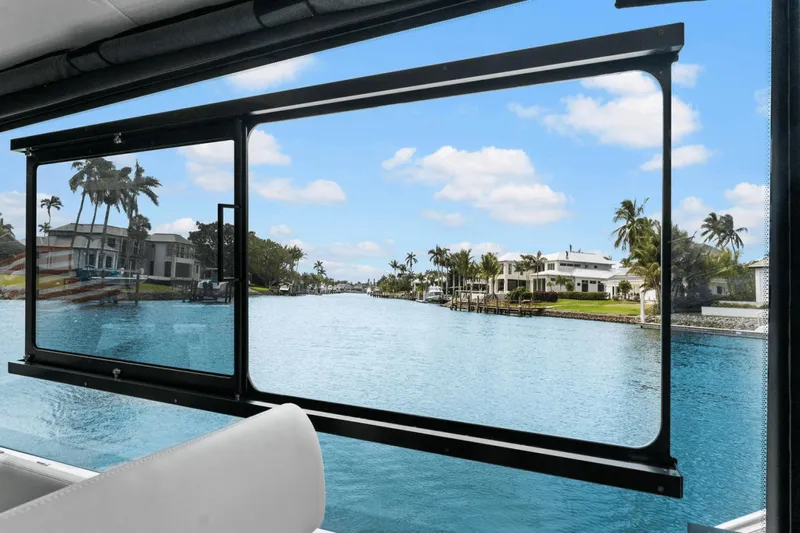 Annabelle IV Yacht Photos Pics View from 2024 MJM 42 yacht window overlooking a serene waterfront with palm trees.
