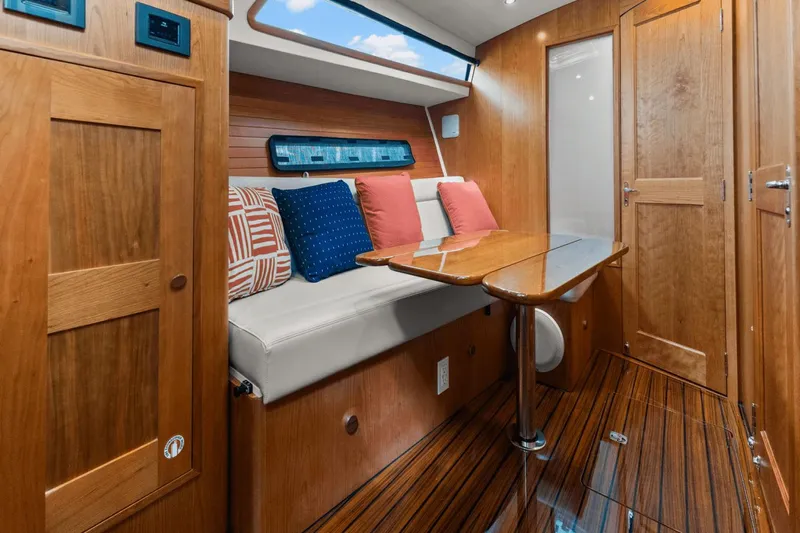 Annabelle IV Yacht Photos Pics 2024 MJM 42 yacht interior with wooden finish, cushioned seating, and elegant table.