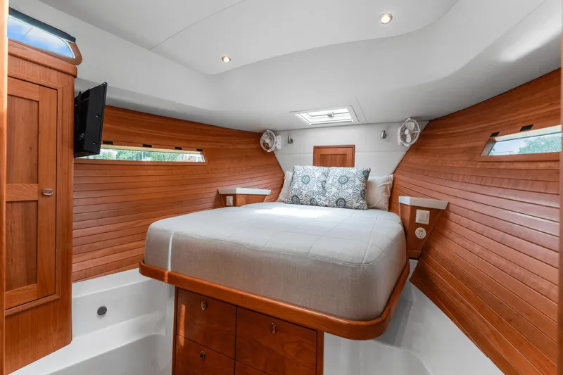 Annabelle IV Yacht Photos Pics Luxurious cabin interior of 2024 MJM 42 yacht with wood paneling and cozy bed.