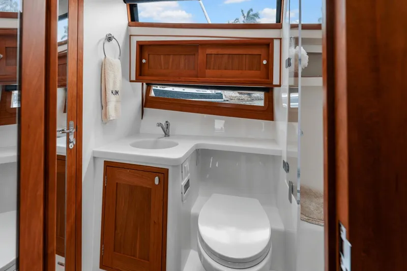 Annabelle IV Yacht Photos Pics 2024 MJM 42 yacht bathroom with wooden cabinets, sink, and toilet.