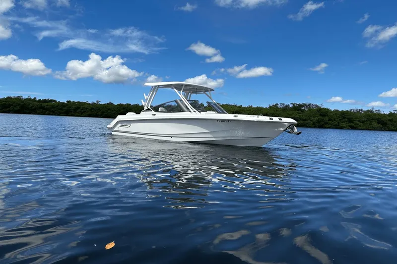  Yacht Photos Pics 2023 Boston Whaler 240 Vantage boat on calm water under blue sky.